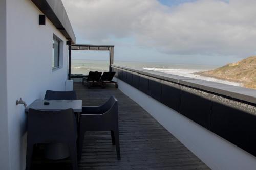 a balcony with a table and chairs and the beach at Well Hotel & Spa in Maceira