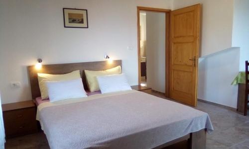 a bedroom with a large bed with two white pillows at Apartments by the sea Valun, Cres - 386 in Valun