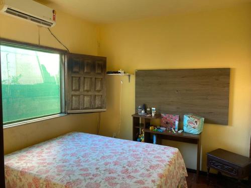 a bedroom with a bed and a large window at Casa grande e bela in Porto Seguro
