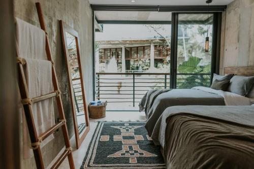 two beds in a room with a window at Cenote + Swim-Up + Luxury Condo in Tulum
