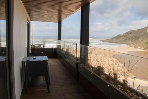 a room with a desk and a view of the beach at Well Hotel & Spa in Maceira