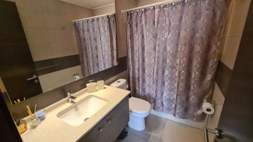 y baño con lavabo, aseo y ducha. en Apartamento Boulevard Poniente, en Viña del Mar