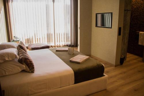 a bedroom with a large bed in front of a window at Well Hotel & Spa in Maceira