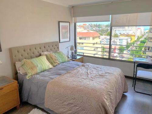 1 dormitorio con cama y ventana grande en Apartamento Boulevard Poniente, en Viña del Mar