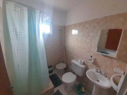 a bathroom with a toilet and a sink and a shower at Departamento América in Puerto Madryn