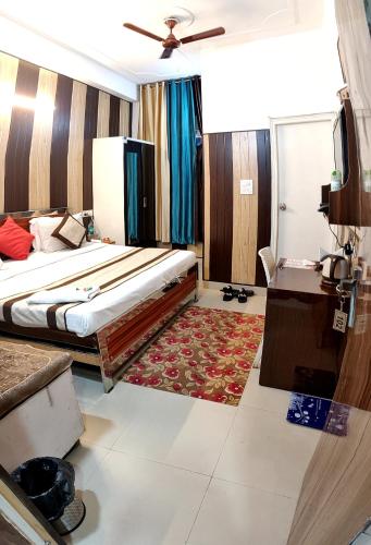 a hotel room with a bed and a desk and a table at Greno House in Greater Noida