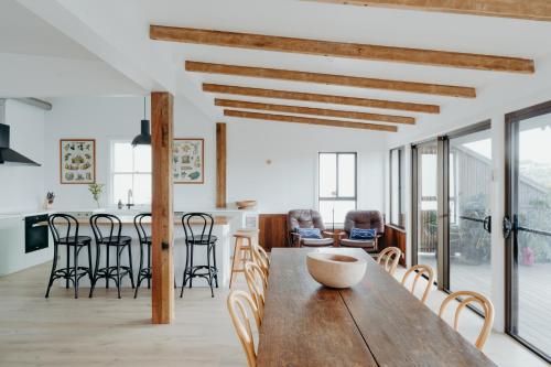 a kitchen and dining room with a wooden table and chairs at Massinger Views in Byron Bay