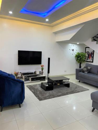 a living room with a flat screen tv on a wall at Entire Serviced Two bedroom duplex Abuja - 24hr WIFI, POWER, OFFICE, FULL KITCHEN in Abuja