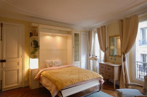une chambre avec un lit, une commode et une fenêtre dans l'établissement Two-Bedroom Apartment Champs-Elysées, à Paris