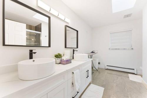 a white bathroom with two sinks and a mirror at Luxury Home In Burnaby/Metrotown/SFU in Burnaby