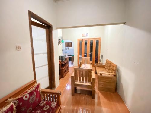 Sadewa homestay batukaras في Batukaras: غرفة معيشة مع طاولة وكراسي
