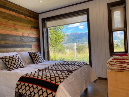 科伊艾科的住宿－Cabaña Pampa Pinuer Coyhaique，一间卧室设有一张床和一个大窗户