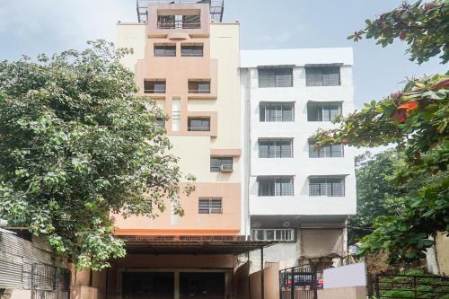 un edificio alto y blanco con árboles delante en River View Near Shaniwar Wada, en Pune