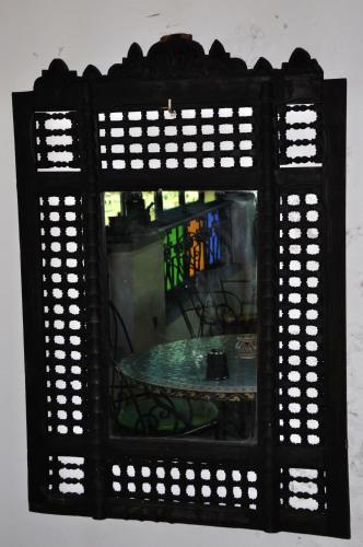 a mirror with a table in a room at Riad Khouloud in Fès