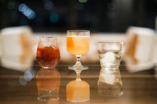 three glasses of different types of drinks on a table at TheMana Village in Tosashimizu