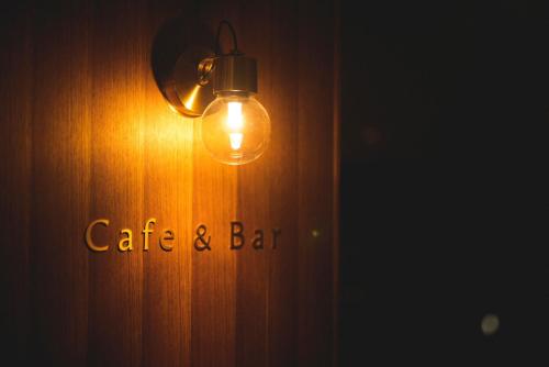 a light hanging on a wall with a cafe and bar sign at TheMana Village in Tosashimizu