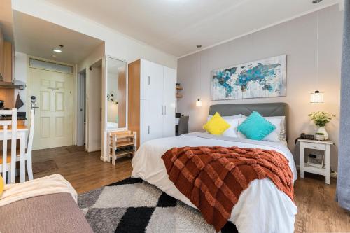 1 dormitorio con 1 cama grande y cocina en AMANI 729, 3 Minutes to Airport, 100mbps Wi-Fi, Free Netflix en Pusok