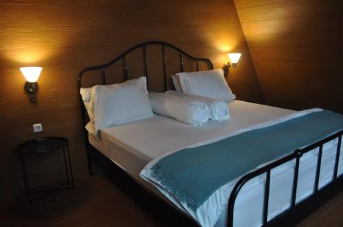 a bedroom with a bed with two pillows and two lights at villa cikole kalaras in Lembang