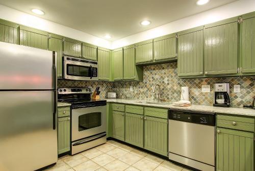 una cucina verde con elettrodomestici in acciaio inossidabile e mobili verdi di PARK STATION 147 condo a Park City