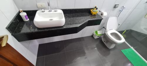 a bathroom with a sink and a toilet at Piscina Climatizada em condomínio - Atibaia SP in Atibaia