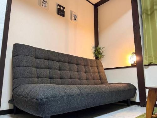 un sofá en una habitación con pared en The Guest House Noah, en Naha