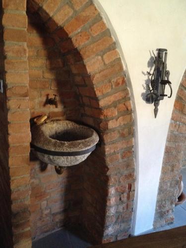 a bathroom with a stone sink in a brick wall at Altes Backhaus in Maranzana in Mombaruzzo