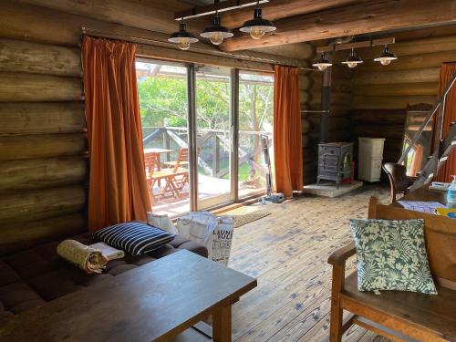 a living room with a couch and a table and a fireplace at BAYMARINAログハウス in Sakaide