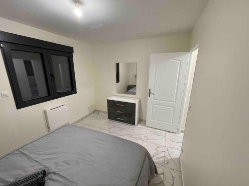 a bedroom with a bed and a dresser and a mirror at Masion belle vue in Sarcelles