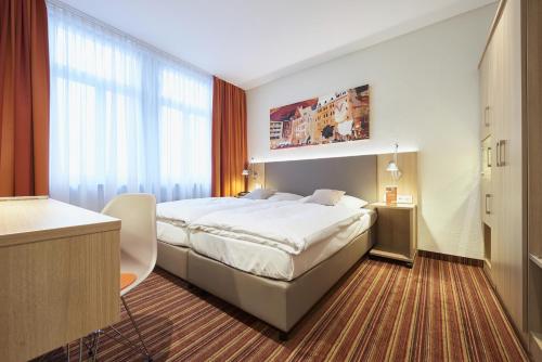 a hotel room with a bed and a desk at Hotel VICTORIA Nürnberg in Nürnberg