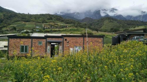 a brick building in the middle of a field of flowers at KOMOWANAN HOMESTAY in Kundasang