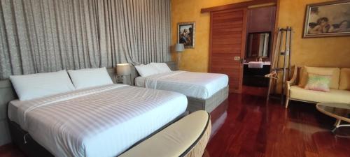 a hotel room with two beds and a chair at The Height Khaoyai Resort in Ban Huai Sok Noi