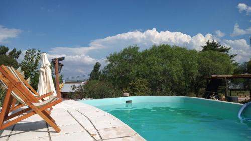 - Piscina con silla y sombrilla en Terrazas del Río en Achiras