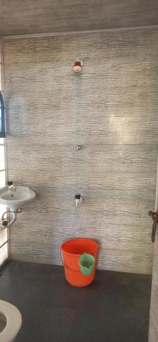 a bathroom with an orange bucket and a sink at Elara Beach View HomeStay in Alleppey