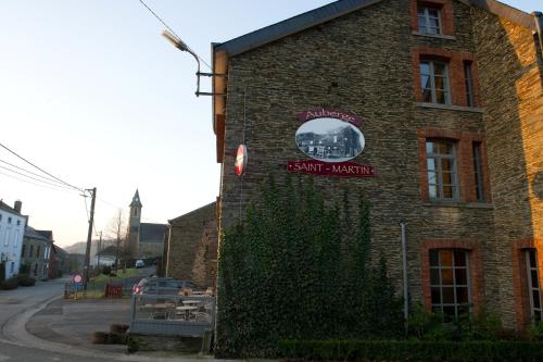 a brick building with a sign on the side of it at Auberge Saint-Martin in Orchimont