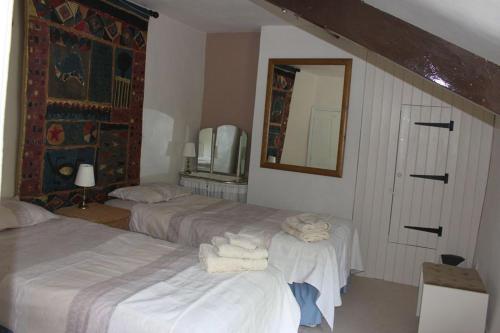 1 dormitorio con 2 camas y espejo en Enniskerry - The Loves Cottage, en Shepton Mallet