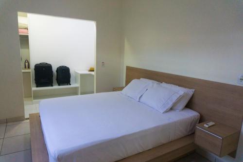 um quarto com uma cama branca e uma janela em Casa Linda em Santarém