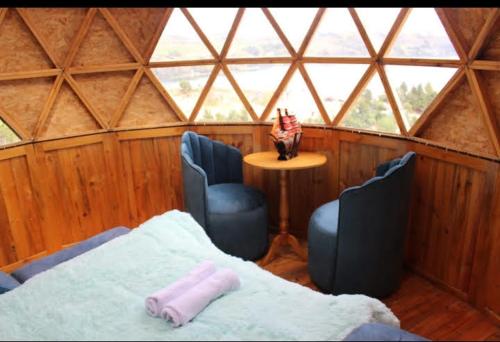 een kamer met 2 stoelen en een bed in een yurt bij Glamping Cronos in Tota