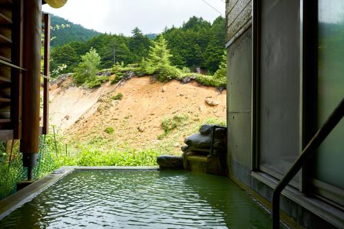 una vista desde la ventana de un tren de un cuerpo de agua en Manza Kogen Hotel, en Tsumagoi