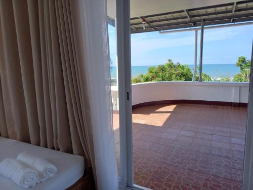 um quarto com uma varanda com vista para o oceano em Seven Waves Beachfront Residence 