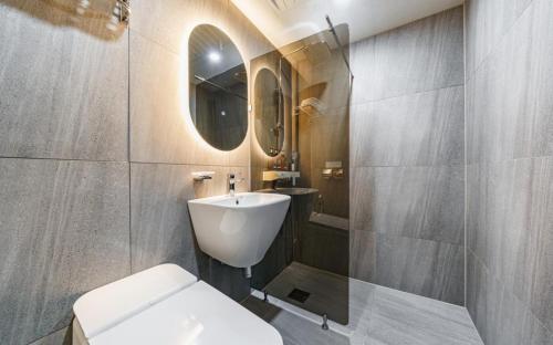 a bathroom with a sink and a toilet and a mirror at Number25 Hotel Namchuncheon in Chuncheon
