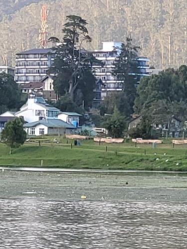 a view of a city from the water at THE WIND LILY - Lake View Luxury Apartment in Nuwara Eliya
