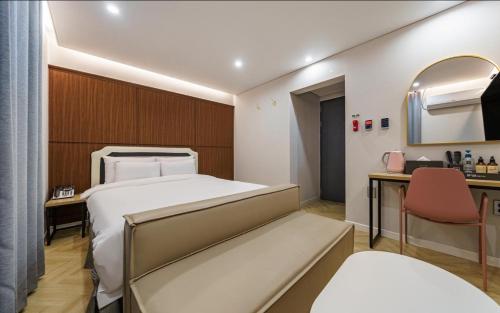 a bedroom with a bed and a desk and a mirror at Number25 Hotel Namchuncheon in Chuncheon