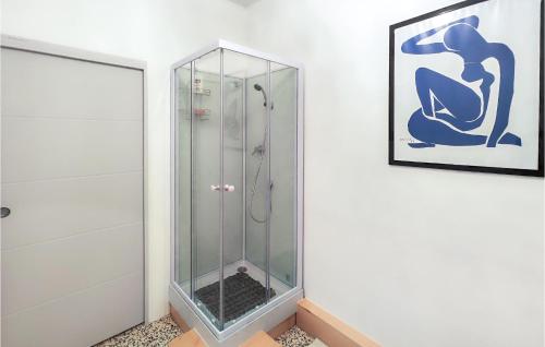 uma cabina de duche em vidro numa casa de banho com uma fotografia na parede em Lovely Home In Gabian With Swimming Pool em Gabian