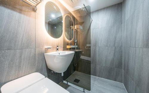 a bathroom with a sink and a toilet and a mirror at Number25 Hotel Namchuncheon in Chuncheon