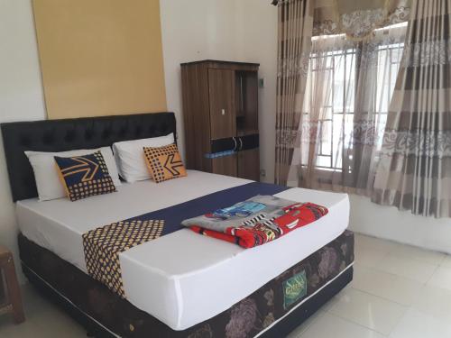 um quarto com uma cama e uma janela em Bintang Khanida Syari'ah em Tjakranegara
