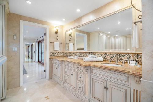 a bathroom with two sinks and a large mirror at 5bdr park lane villa-basketball court-pool-views in Los Angeles