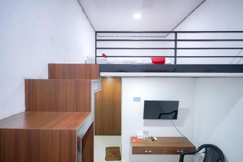 a small room with a bunk bed and a desk at RedDoorz at Jalan Basuki Rahmat Lampung in Lampung