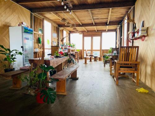 a room with wooden benches and tables and a refrigerator at Nẫu Ecovalley 