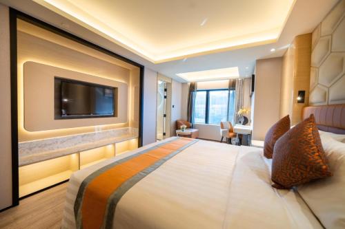 a hotel room with a large bed and a flat screen tv at Hotel Golden Dragon in Macau