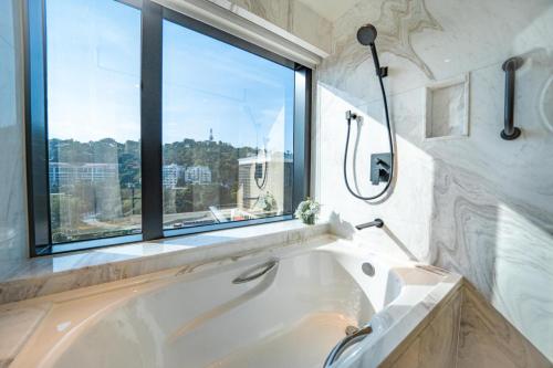 a bath tub in a bathroom with a window at Hotel Golden Dragon in Macau